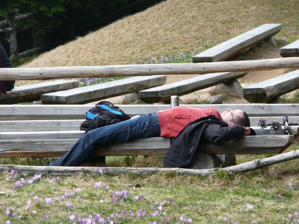 Turysta leży na ławce, odpoczywa