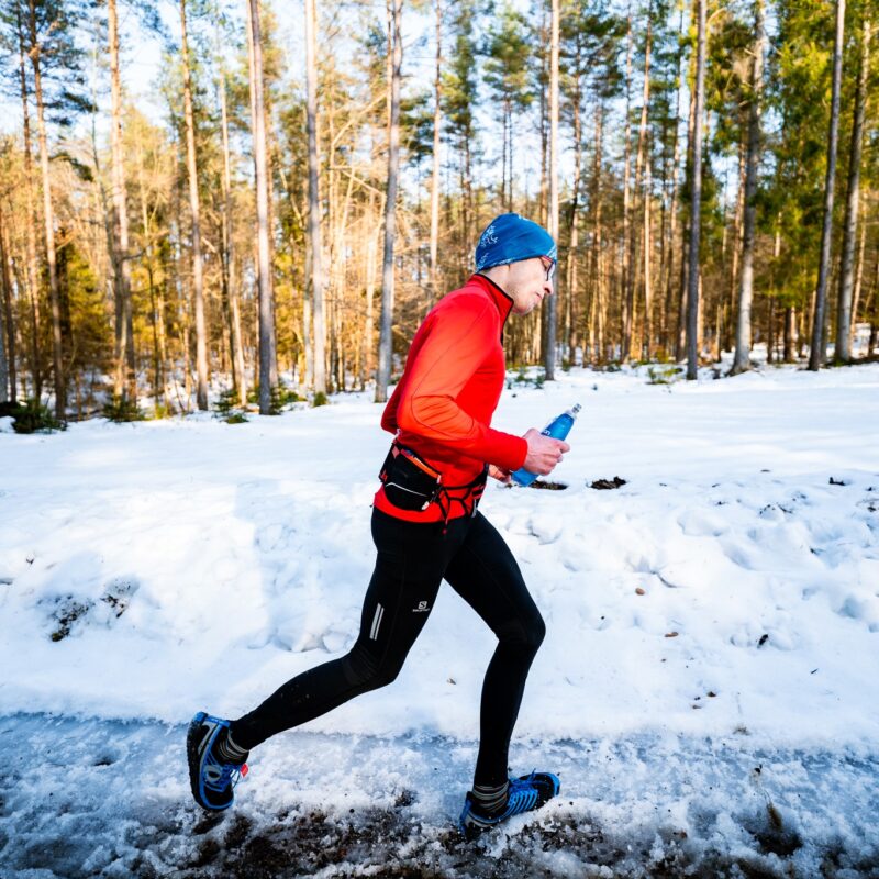 biegacz na tle śniegu i lasu w tle